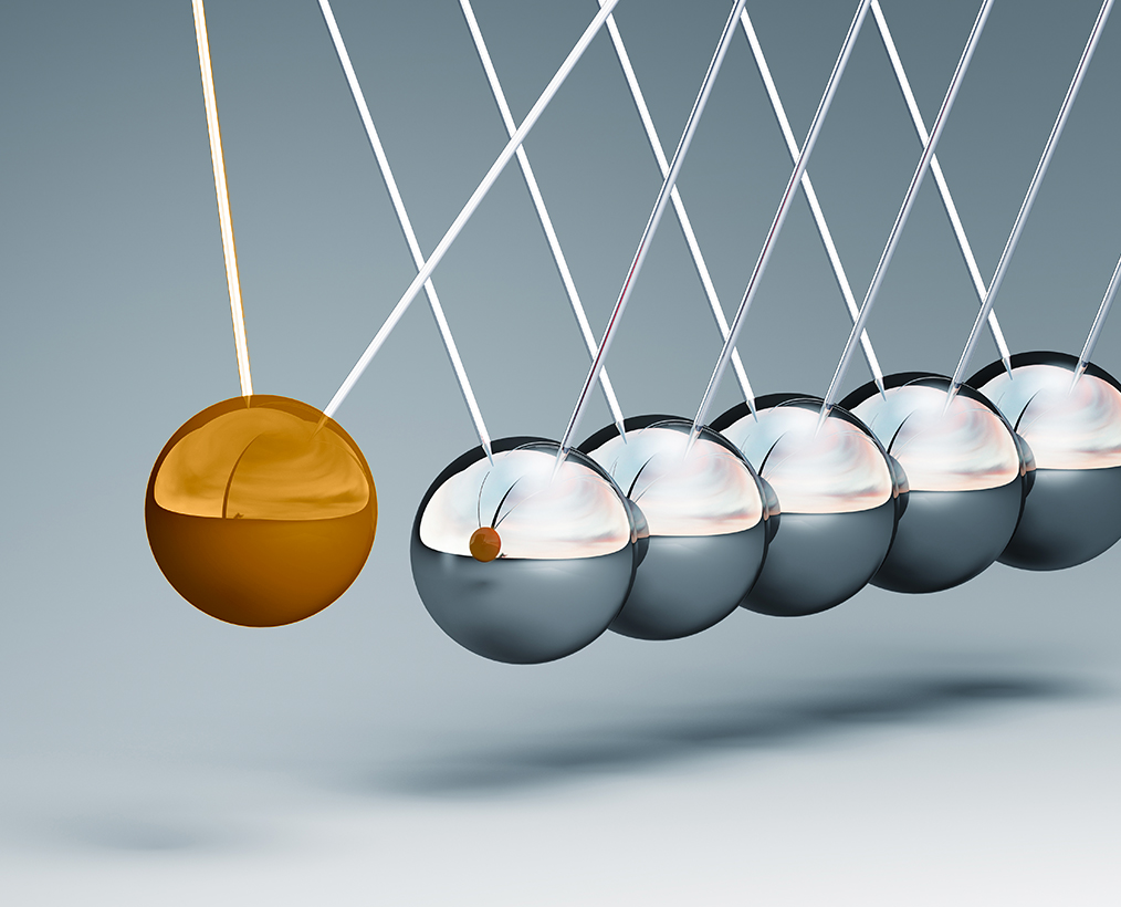 Newton's cradle with one ball poised to strike the next one in the series